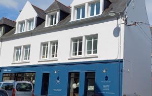 a white building with blue doors and windows at Appartement BZH in Plougastel-Daoulas