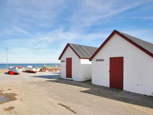 two buildings on the beach with a boat at Holiday Home Usko - 250m from the sea by Interhome in Torsted