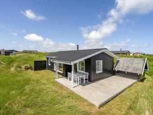 a tiny house with a deck in a field at Holiday Home Usko - 250m from the sea by Interhome in Torsted +15 photos