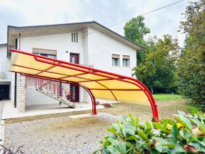a large red and yellow sculpture in front of a house at Casa fiorita in Camisano Vicentino