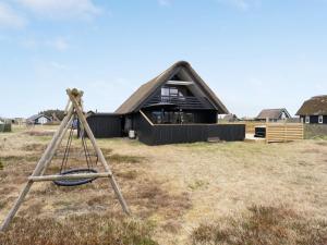 a swing in front of a house at Holiday Home Kristanna - 150m from the sea by Interhome in Harboør