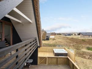 a deck with a grill on the side of a house at Holiday Home Kristanna - 150m from the sea by Interhome in Harboør