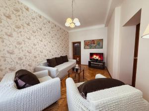 a living room with two white couches and a fireplace at Kyiv Sofia Apartment in Kyiv