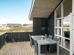 a patio with a table and chairs on a balcony at Holiday Home Frido - 400m from the sea by Interhome in Torsted