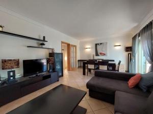a living room with a couch and a flat screen tv at Vilapeti by SAPvillas in Vilamoura
