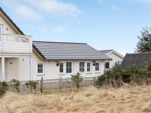 a white house with a fence in front of it at Apartment Siór - 200m from the sea by Interhome in Torsted