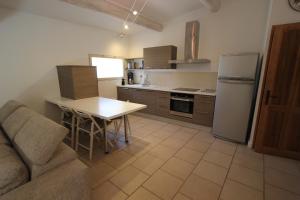 a kitchen with a couch and a table and a refrigerator at Le gîte des Limites in Rognonas +20 photos