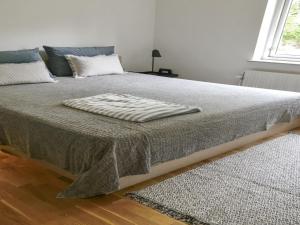 a bed with a blanket on it in a bedroom at Holiday Home Flor - 900m from the sea by Interhome in Torsted