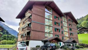 a large building with cars parked in front of it at Résidence Pointe de Bellevue in Val-d'Illiez
