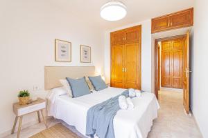 Un dormitorio con una gran cama blanca con almohadas azules. en EL MIRADOR La Manga del Mar Menor, en La Manga del Mar Menor