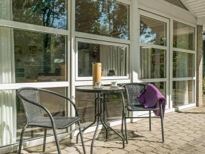 a porch with two chairs and a table with a candle at Holiday Home Aslak - 350m from the sea by Interhome in Torsted