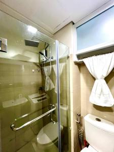 Un baño con ducha, inodoro y ventana. en Pasay Mall of Asia Shore1 Residences Tower C2, en Manila