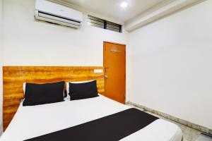 Un dormitorio con una cama con cabecero de madera. en Hotel O Hotel New Hitech Inn, en Hyderabad 21 fotos más