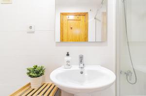 Un baño con lavabo y puerta de madera. en EL MIRADOR La Manga del Mar Menor, en La Manga del Mar Menor 38 fotos más