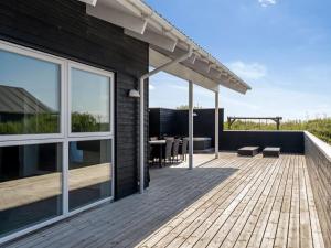 une terrasse avec une table et des chaises sur une maison dans l'établissement Holiday Home Markku - 400m from the sea by Interhome, à Harboør
