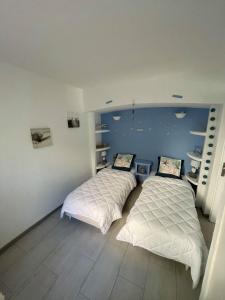 two beds in a room with blue walls and wooden floors at BAS DE VILLA, Mer Piscine et SPA in Roquebrune-sur-Argens