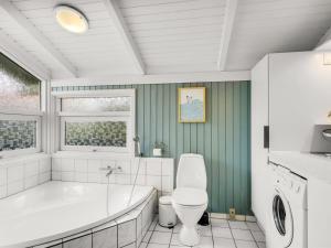 a bathroom with a tub and a toilet and a sink at Holiday Home Laurentius - 300m from the sea by Interhome in Torsted