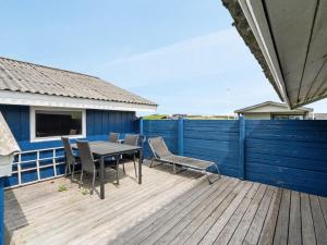 une terrasse avec une table et des chaises ainsi qu'une clôture bleue dans l'établissement Holiday Home Joern - 300m from the sea by Interhome, à Torsted
