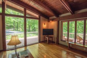 un soggiorno con ampie finestre e TV di Private and Modern Blue Ridge Mountain Chalet- Sleeps 6 Dogs Welcome a Grassy Creek