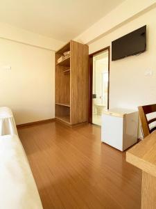 a room with a bed and a television in a room at Lady Laura Hotel 