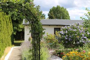 un arco en un jardín con flores en Bungalow _Carpe diem_, en Heringsdorf