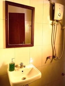 une salle de bains avec un lavabo et un miroir dans l'établissement The Peace Haven, à Kampala