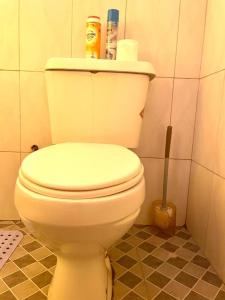 une salle de bain avec des toilettes blanches dans une chambre dans l'établissement The Peace Haven, à Kampala