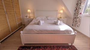 a bedroom with a large white bed with two lamps at Grape Escape - Appartement avec Terrasse et Garage in Rouffach