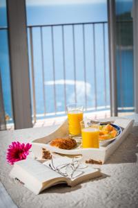 uma mesa com um prato de comida e dois copos de sumo de laranja em Apartment Love and Hope em Dubrovnik