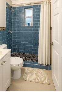 a blue tiled bathroom with a toilet and a window at Downtown Miami full apartment with kitchen in Miami