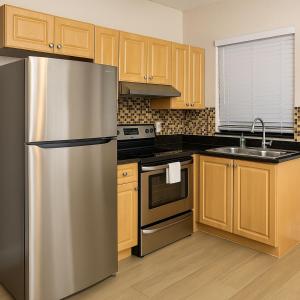 a kitchen with a stainless steel refrigerator and wooden cabinets at Downtown Miami full apartment with kitchen in Miami