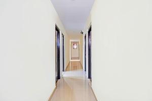 a hallway with white walls and tile floors at Super Collection O Guduvancheri Railway Station in Chennai