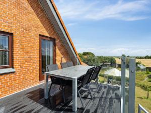 a table and chairs sitting on a deck at Holiday Home Amely - 500m from the sea by Interhome in Sæby +29 photos