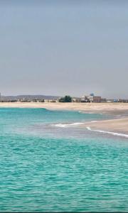 een waterlichaam met een strand op de achtergrond bij Pink Beaches Guest Houses in Al Ḩadd +54 foto's