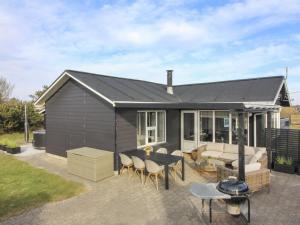 a small black shed with a table and chairs at Holiday Home Jespar - 300m from the sea by Interhome in Løkken