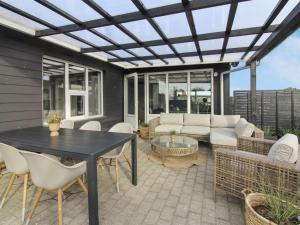 a patio with a couch and a table and chairs at Holiday Home Jespar - 300m from the sea by Interhome in Løkken