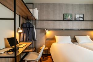 a bedroom with a bed and a desk with a computer at ibis Bordeaux Nord Carbon Blanc in Carbon-Blanc +30 photos