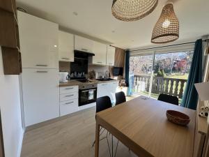 eine Küche mit Holztisch und ein Esszimmer in der Unterkunft Appartement 2 pièces 4 pers terrasse parking Les Carroz d'Arâches - FR-1-572-293 in Arâches-la-Frasse