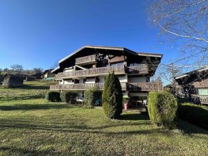 ein Gebäude auf einem Hügel mit Büschen davor in der Unterkunft Appartement 2 pièces 4 pers terrasse parking Les Carroz d'Arâches - FR-1-572-293 in Arâches-la-Frasse