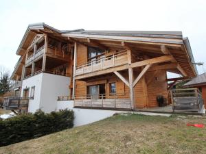 ein großes Holzhaus mit Balkon auf einem Hügel in der Unterkunft 3 pièces cosy : Jardin, Wifi, Parking, 700m des pistes, 50m des commerces - FR-1-572-44 in Arâches-la-Frasse