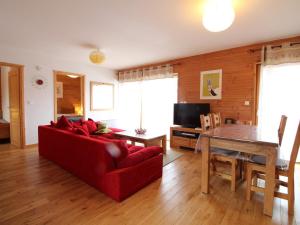 ein Wohnzimmer mit einem roten Sofa und einem Tisch in der Unterkunft 3 pièces cosy : Jardin, Wifi, Parking, 700m des pistes, 50m des commerces - FR-1-572-44 in Arâches-la-Frasse