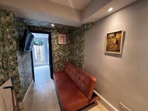a living room with a couch and a television at Rest Boutique Acton in London