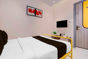 a bedroom with a bed and a tv on the wall at Townhouse Oak Vaishali Nagar Jaipur in Jaipur +18 photos