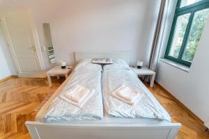 a white bed with two pillows on it in a room at Beautiful old building apartment in Dresden