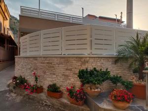 a brick wall with pots of plants and flowers at Petra Nova in Sarno