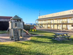 a playground with a slide and a table and a building at Apartment Lenya - 150m from the sea by Interhome in Løkken