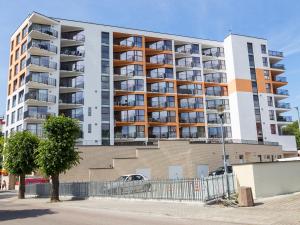 a large apartment building in front of a building at Apartament Międzyzdroje Horyzont Blue in Międzyzdroje