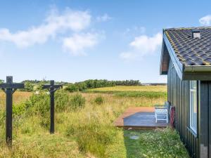 un banco en una terraza junto a una casa en Holiday Home Hildegardt - 1km from the sea by Interhome, en Løkken