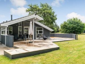 a house with a deck and an umbrella at Holiday Home Dimo - 700m from the sea by Interhome in Løkken