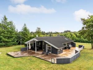 a modular home with a deck and a house at Holiday Home Dimo - 700m from the sea by Interhome in Løkken